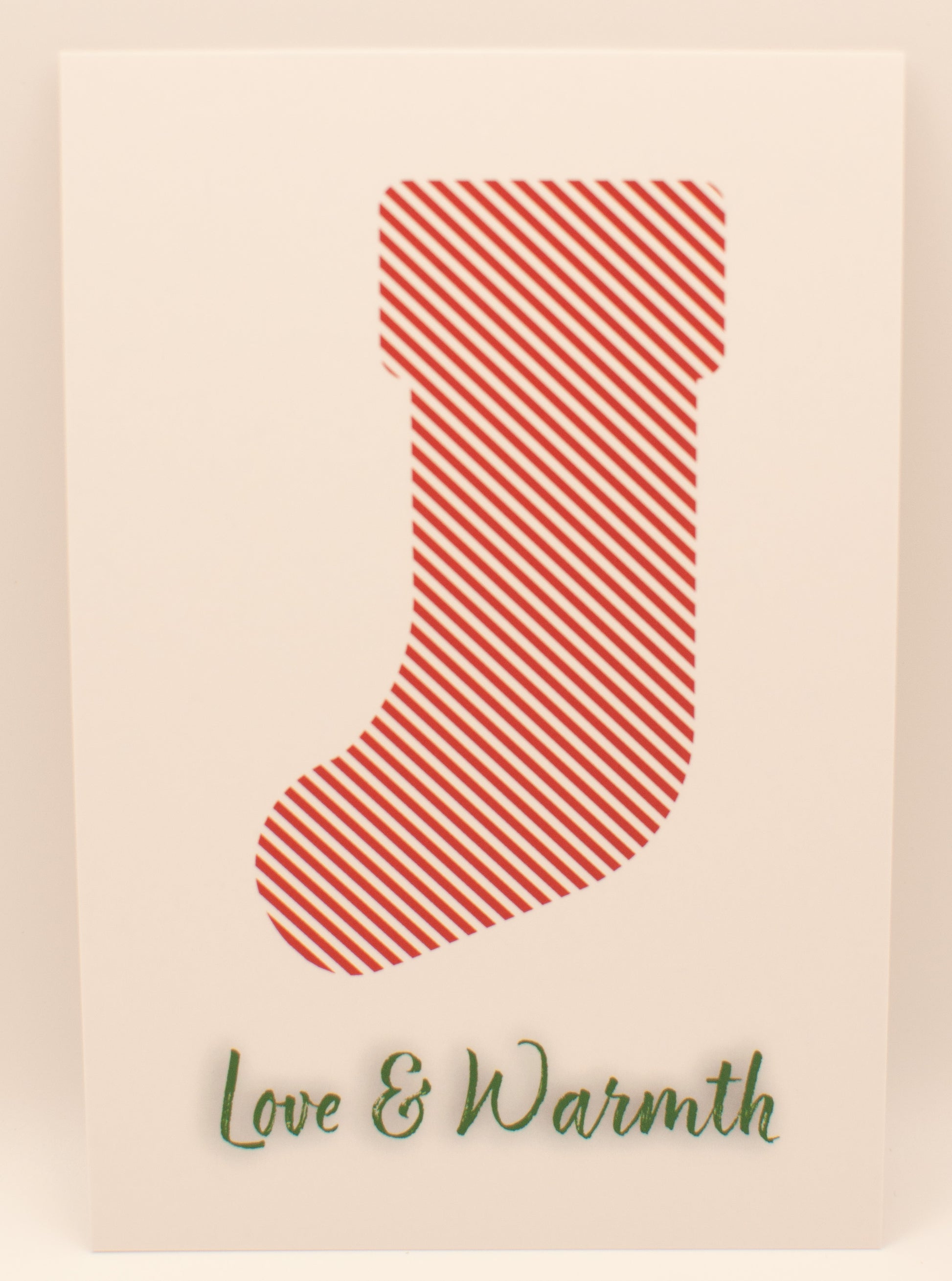 Red striped stocking with 'Love & Warmth' text on a beige background
