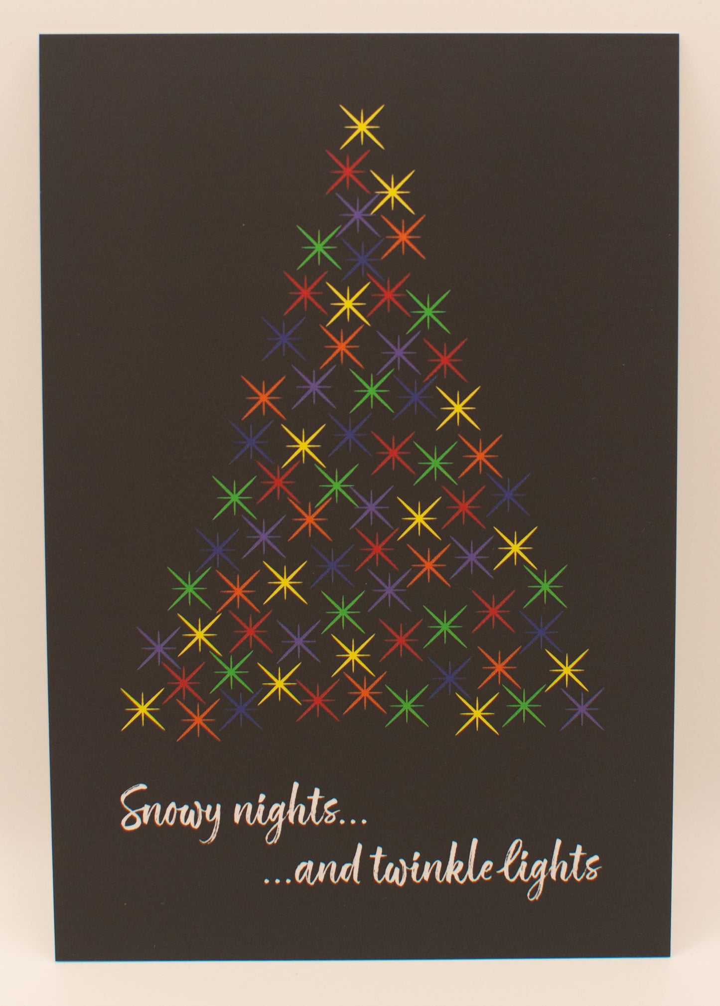 Colorful Christmas tree design on a dark background with text 'Snowy nights...and twinkle lights'.