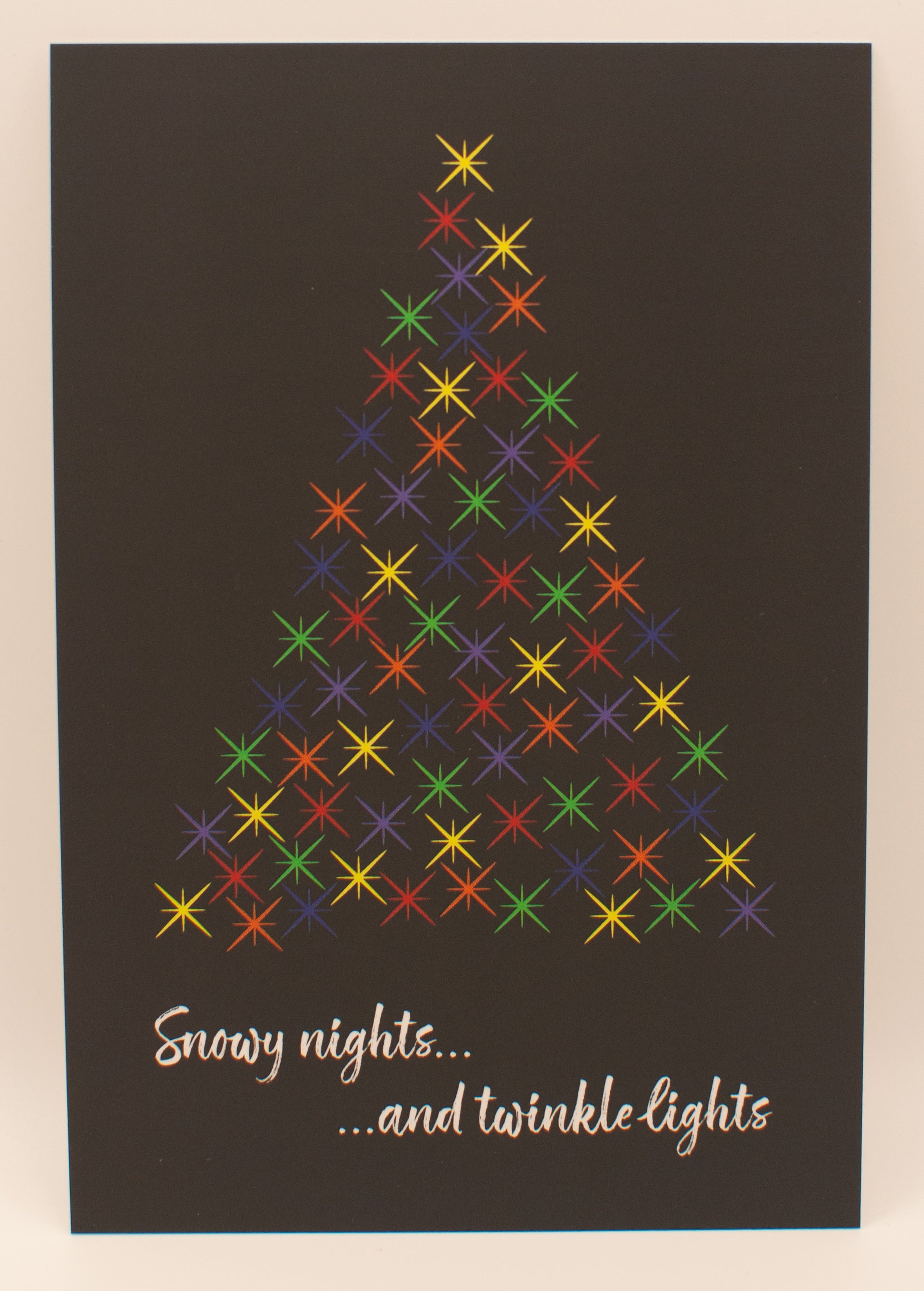 Colorful Christmas tree design on a dark background with text 'Snowy nights...and twinkle lights'.