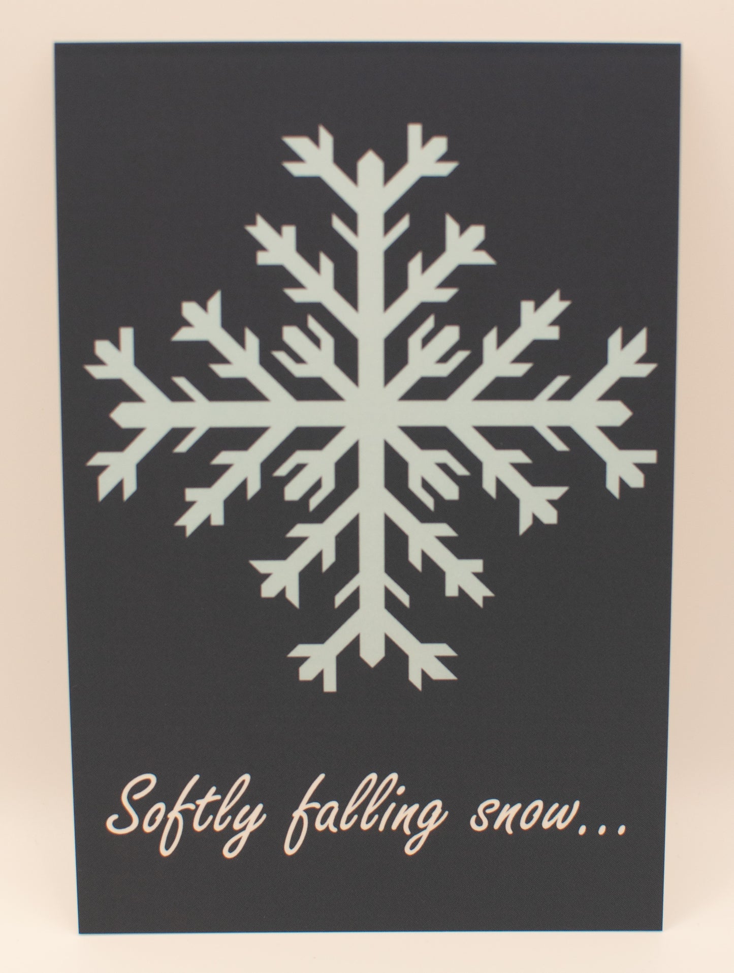 White snowflake design on a black background with text 'Softly falling snow...'