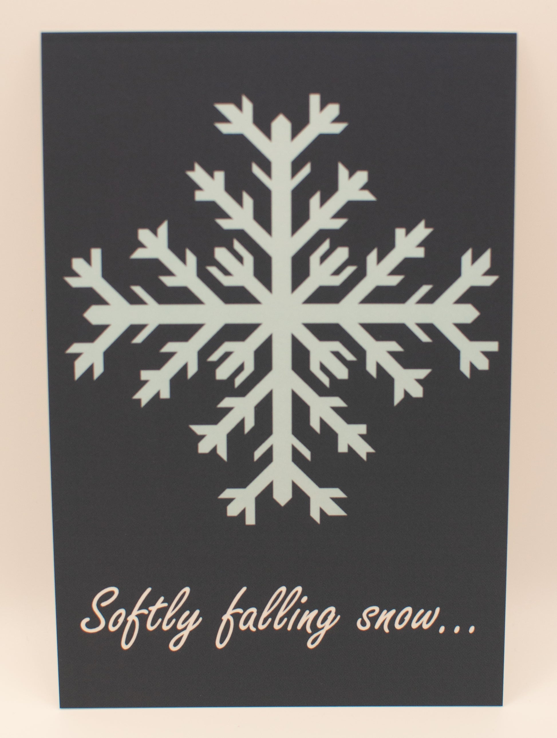 White snowflake design on a black background with text 'Softly falling snow...'