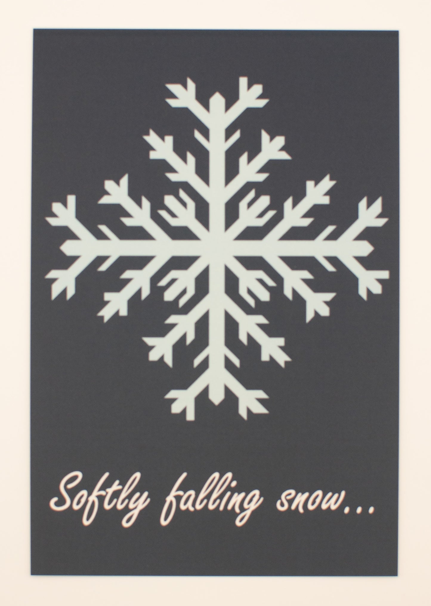 White snowflake on a dark gray background with text 'Softly falling snow...'.