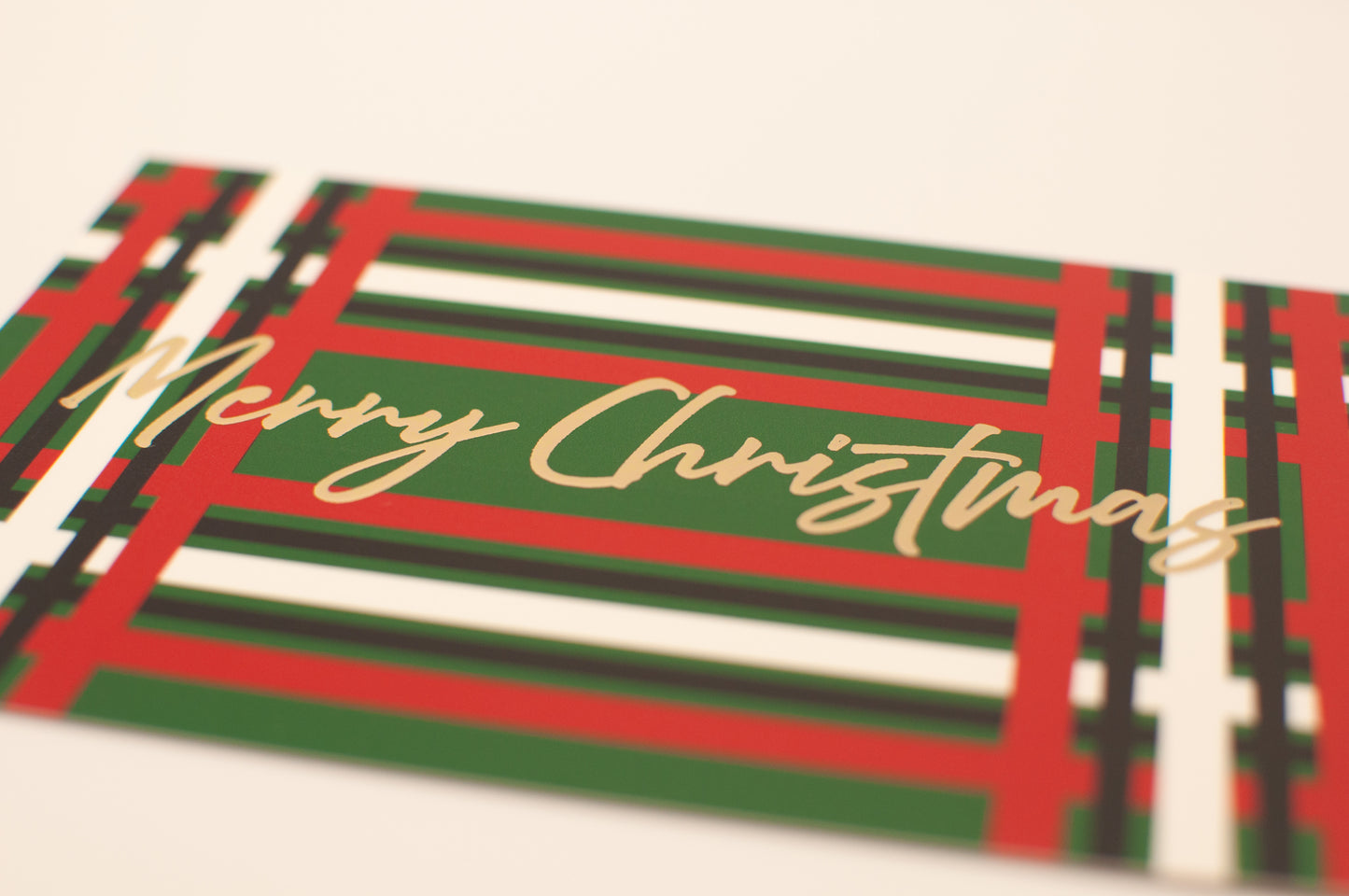 Merry Christmas card with red, green, and white plaid pattern