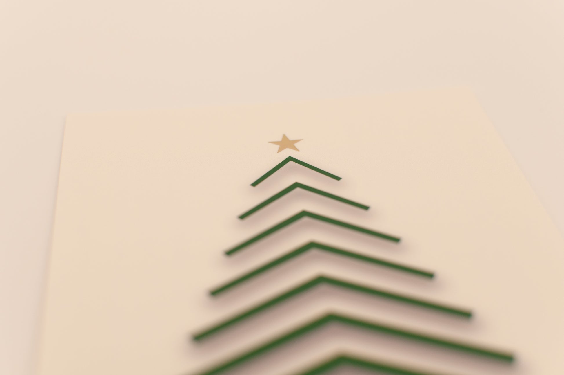 Simple Christmas tree made of green paper on a beige background