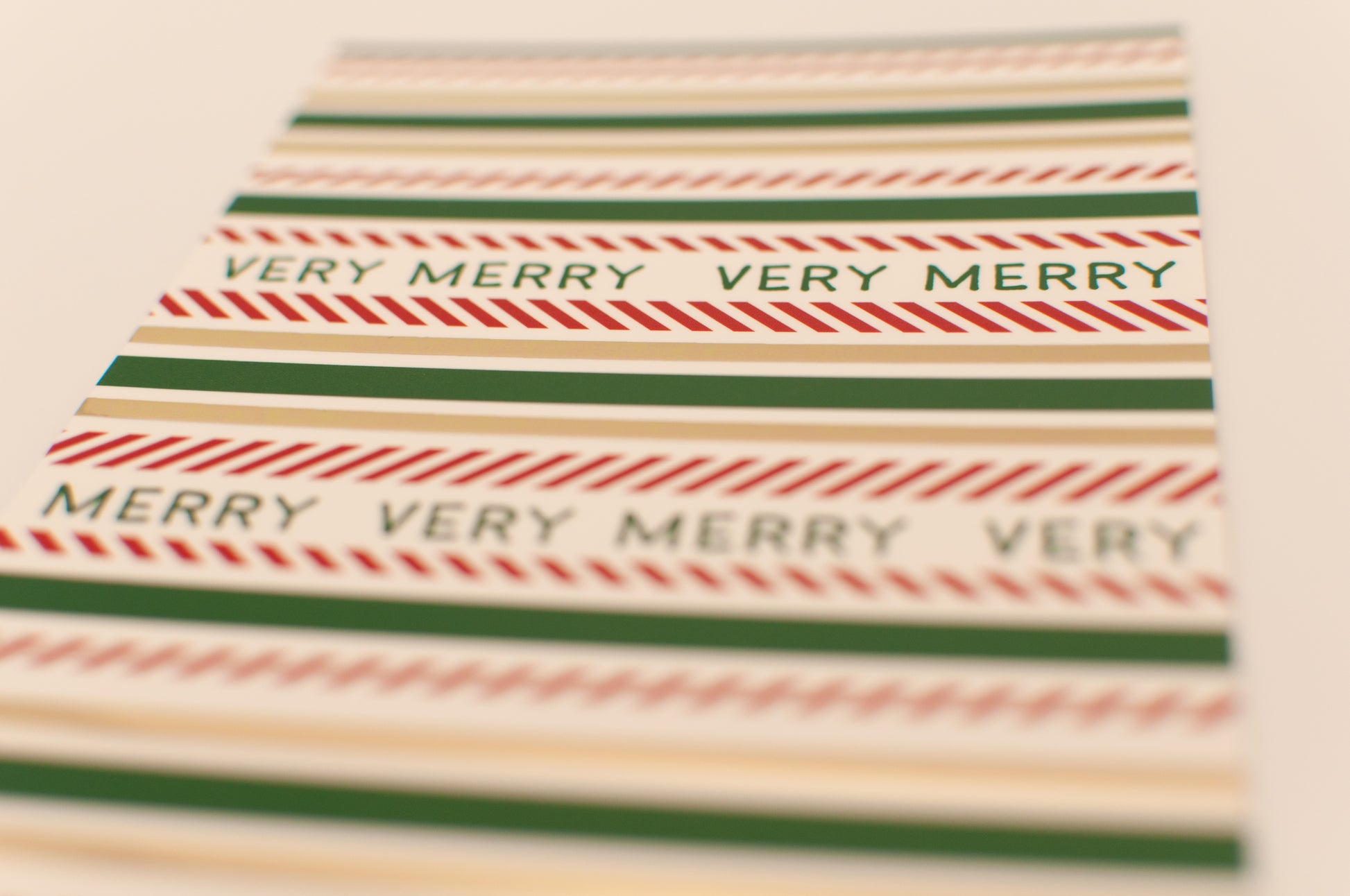 Striped paper with 'Very Merry Very Merry' text on a beige background